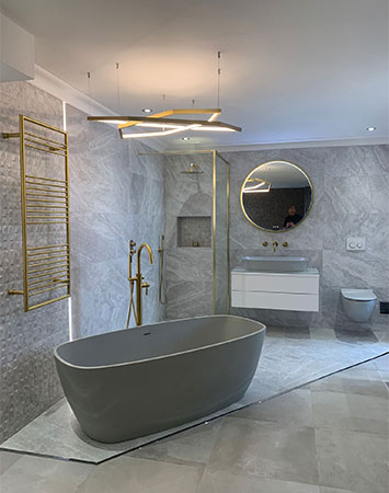 Luxury bathroom display with bath toilet sink mirror and lighting in our shop near Twickenham